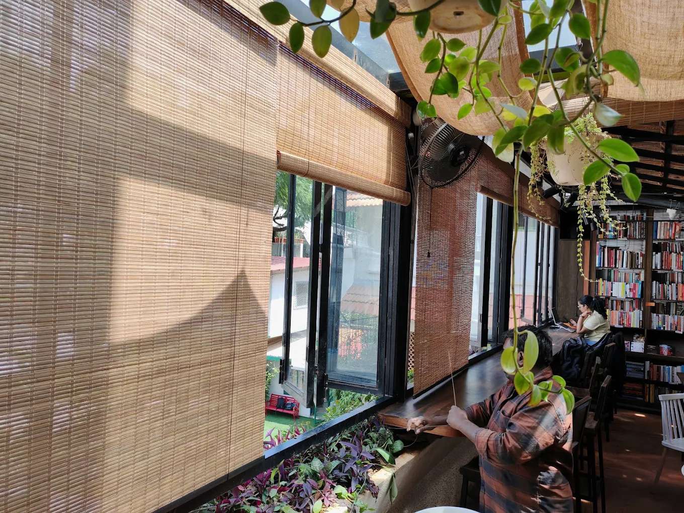 Bamboo blinds along the windows of a café, with afternoon light coming through the weave