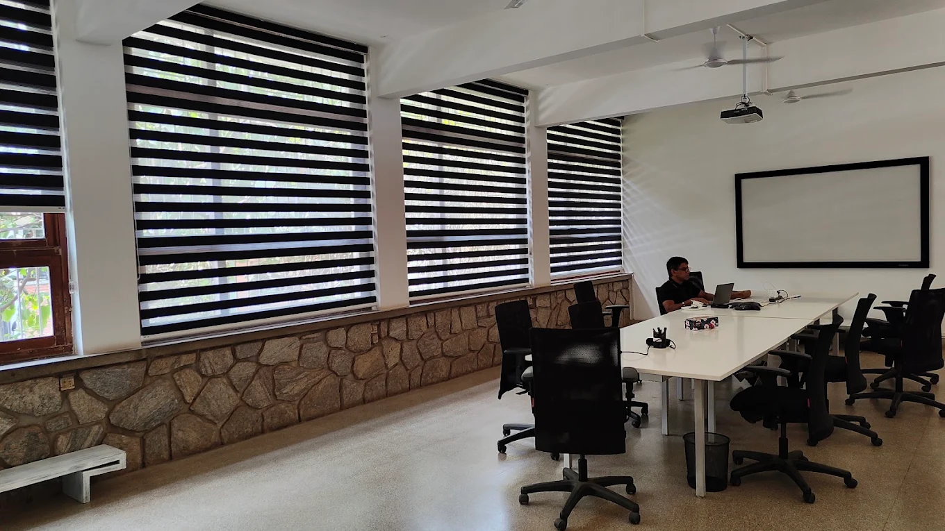 Black and white zebra blinds across the windows of a meeting room